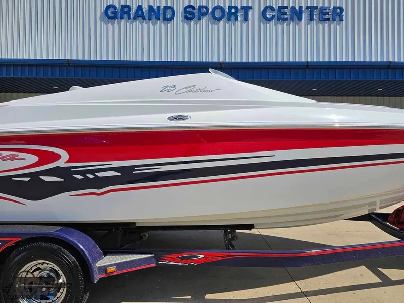 Slide: The Image of 2008 Baja 23 Outlaw boat with red and black graphics at Grand Sport Center. - 4