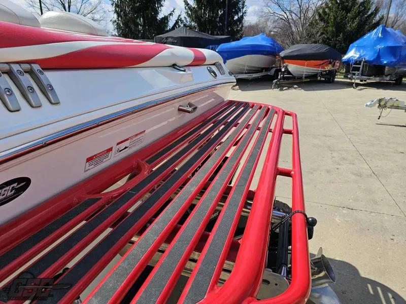 Slide: The Image of 2008 Baja 23 Outlaw boat with red accents and swim platform in a marina. - 42