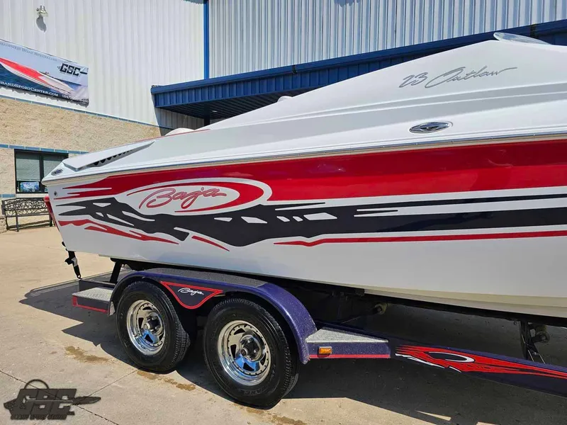 Slide: The Image of 2008 Baja 23 Outlaw boat with vibrant red and black graphics on a trailer. - 6