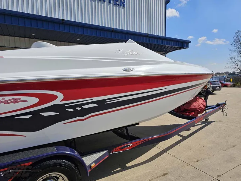 Slide: The Image of 2008 Baja 23 Outlaw speedboat with red and black graphics on a trailer. - 9