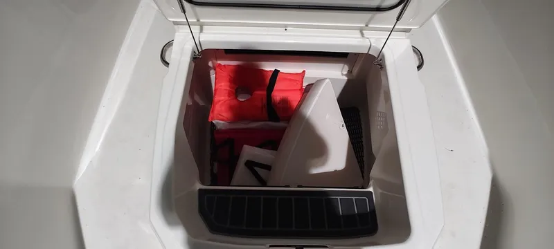 Slide: The Image of 2023 Boston Whaler 220 Dauntless storage compartment with life jackets and equipment. - 17