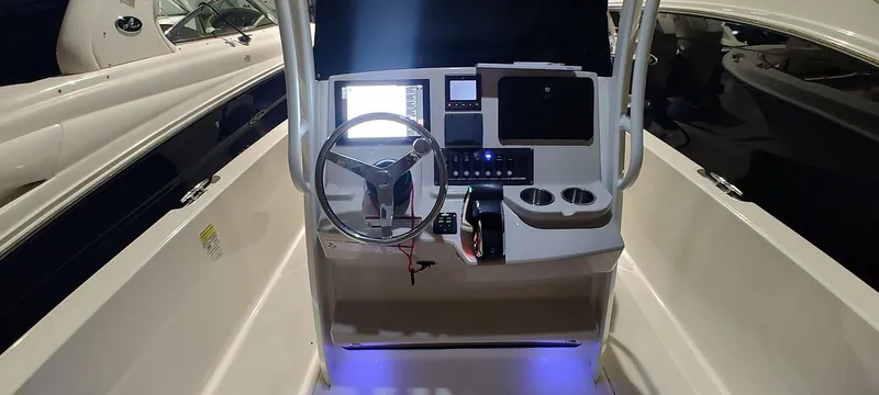 Slide: The Image of 2023 Boston Whaler 220 Dauntless boat console with steering wheel and electronic controls. - 19