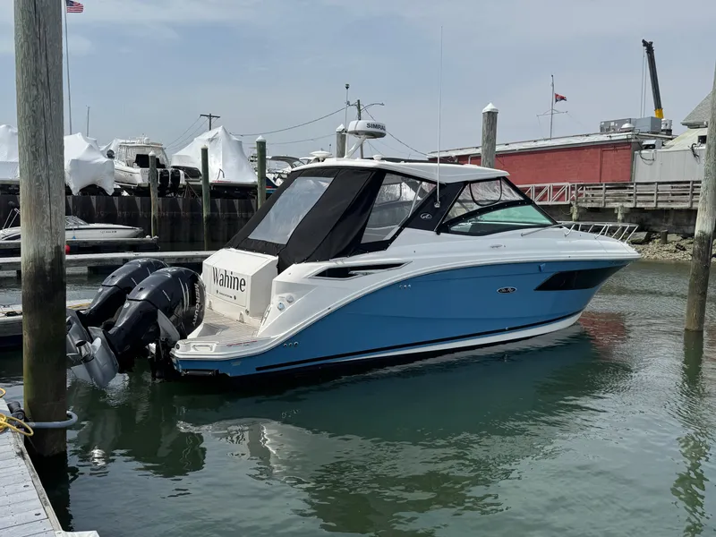 Slide: The Image of 2021 Sea Ray Sundancer 320 OB boat docked in marina, featuring sleek design and twin outboard engines. - 0