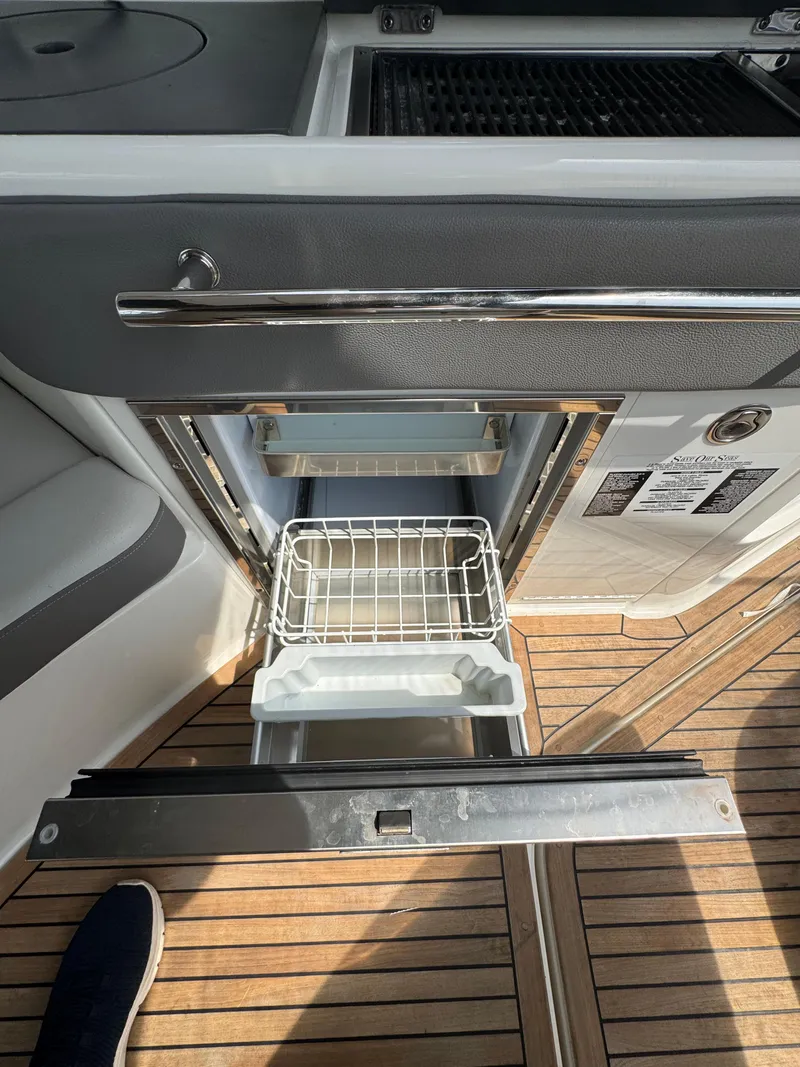 Slide: The Image of 2021 Sea Ray Sundancer 320 OB galley with open drawer and wooden flooring. - 18