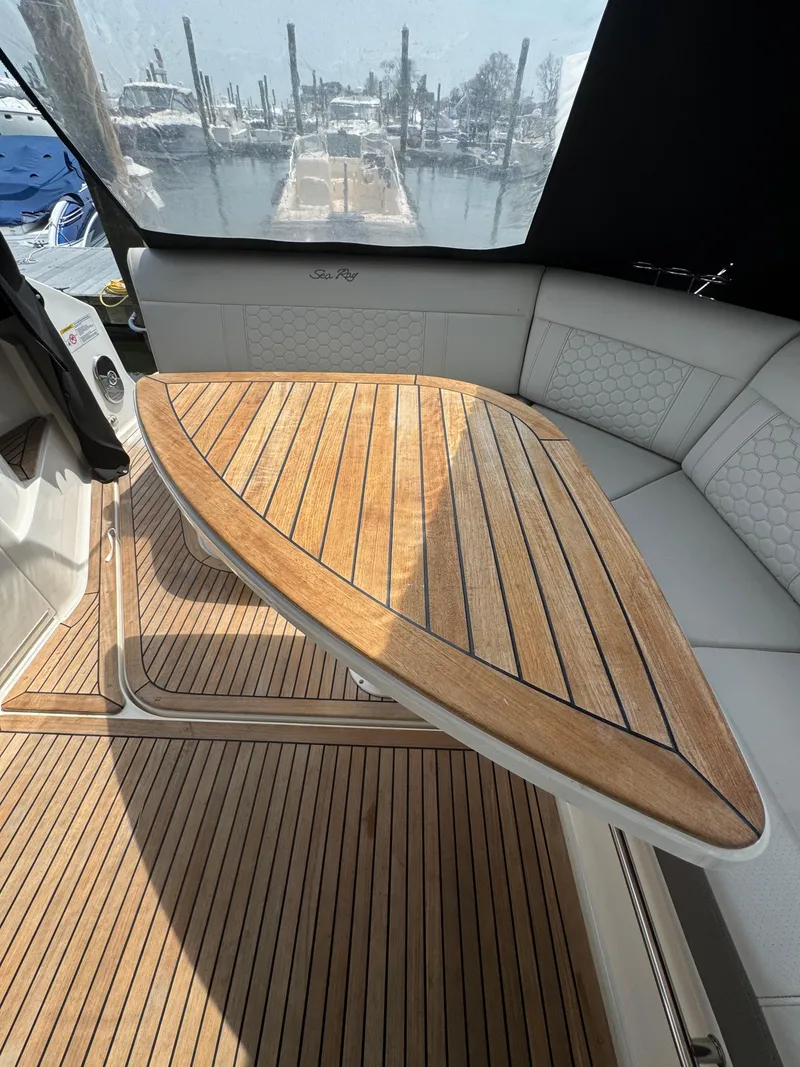 Slide: The Image of 2021 Sea Ray Sundancer 320 OB interior with wooden table and seating. - 19