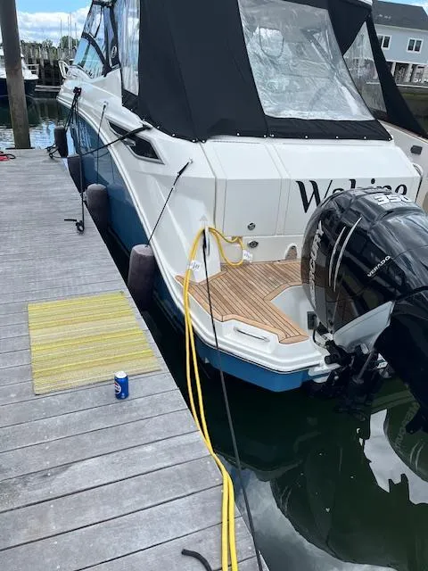Slide: The Image of 2021 Sea Ray Sundancer 320 OB docked, featuring outboard motor and black canopy. - 2