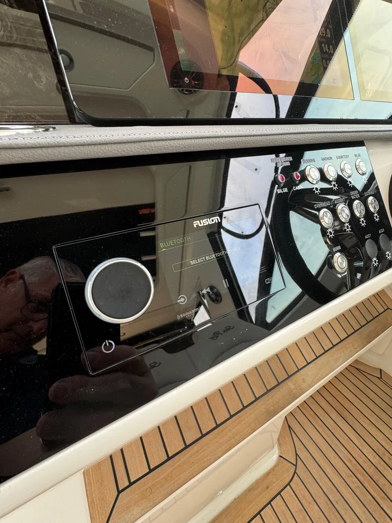 Slide: The Image of 2021 Sea Ray Sundancer 320 OB dashboard with controls and Fusion audio system. - 29