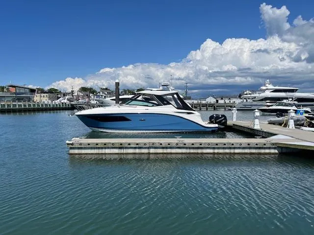 Slide: The Image of 2021 Sea Ray Sundancer 320 OB docked at marina under blue sky. - 3
