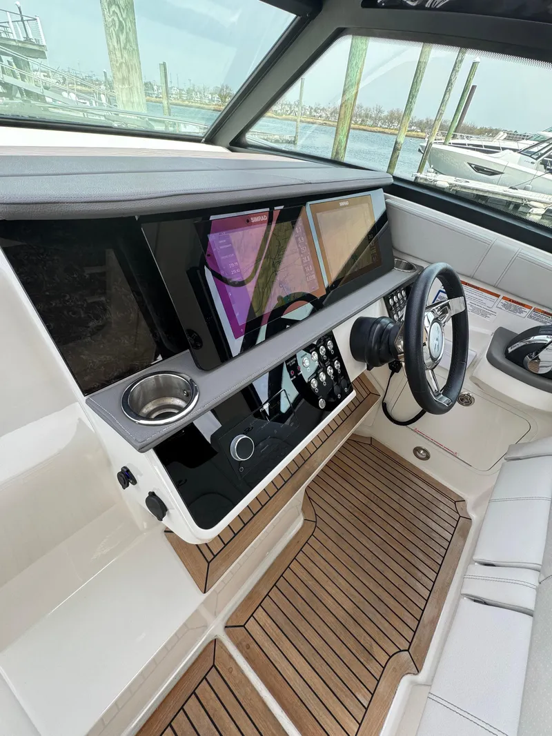 Slide: The Image of 2021 Sea Ray Sundancer 320 OB helm with modern controls and wood accents. - 30