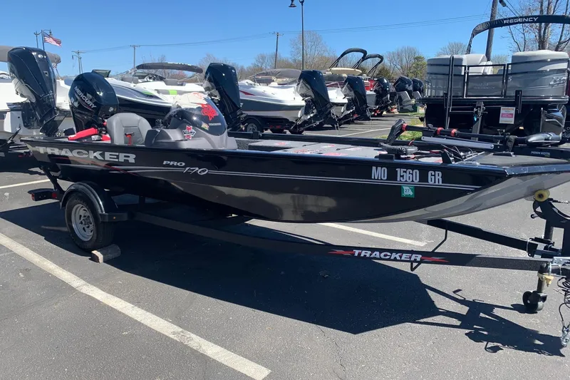 Slide: The Image of 2024 Tracker PRO170 boat on trailer in parking lot, surrounded by other boats. - 5