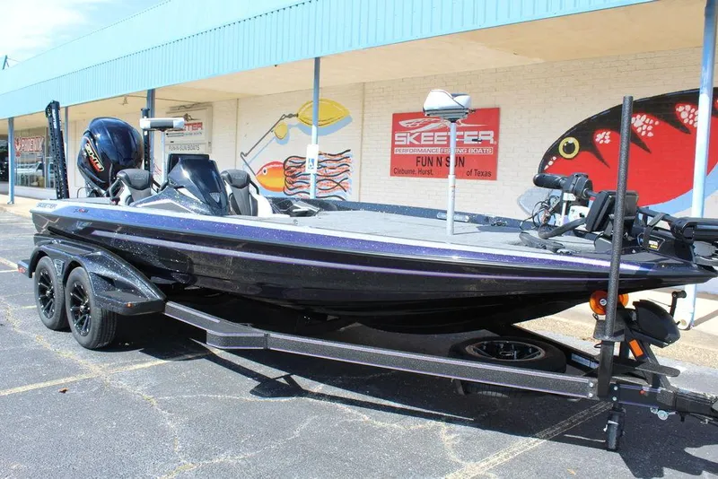Slide: The Image of 2025 Skeeter FXR21L bass boat parked outside a store, showcasing sleek design and modern features. - 10