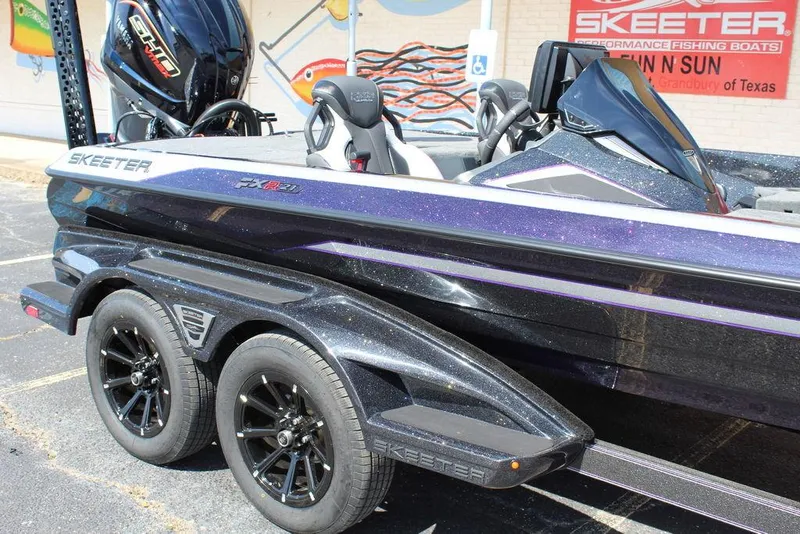 Slide: The Image of 2025 Skeeter FXR21L boat with sleek design and dual axle trailer. - 11