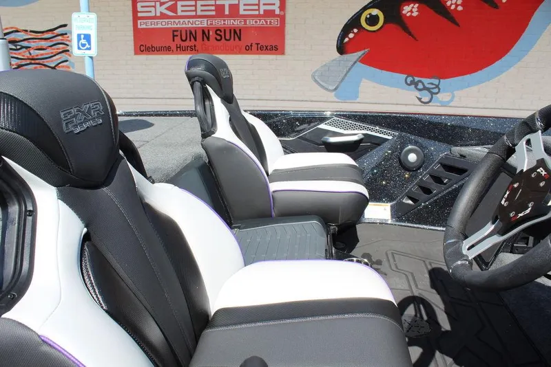Slide: The Image of 2025 Skeeter FXR21L boat interior with sleek black and white seats, steering wheel, and logo. - 15