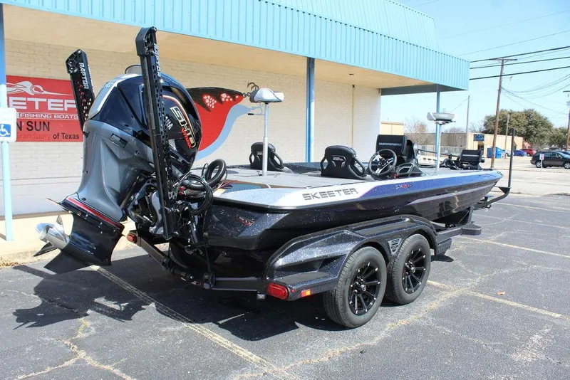 Slide: The Image of 2025 Skeeter FXR21L boat on trailer, parked outside dealership. - 4