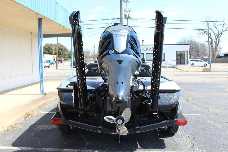Slide: The Image of 2025 Skeeter FXR21L boat rear view with powerful outboard motor in parking lot. - 5