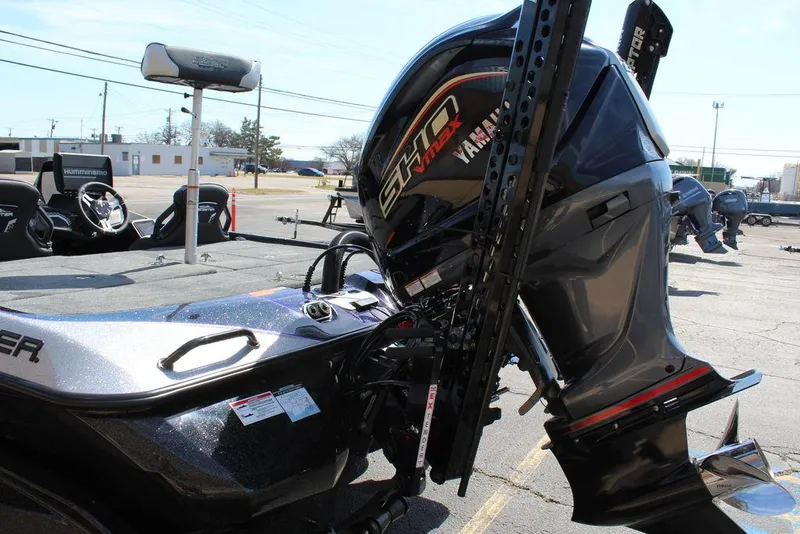 Slide: The Image of 2025 Skeeter FXR21L boat with powerful outboard motor in a parking lot. - 6