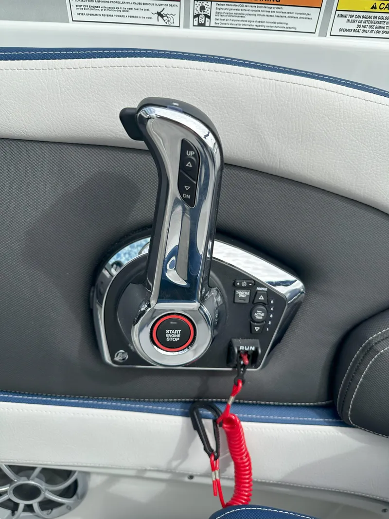 Slide: The Image of 2025 Crownline E235 boat throttle control with start/stop button and safety lanyard. - 12