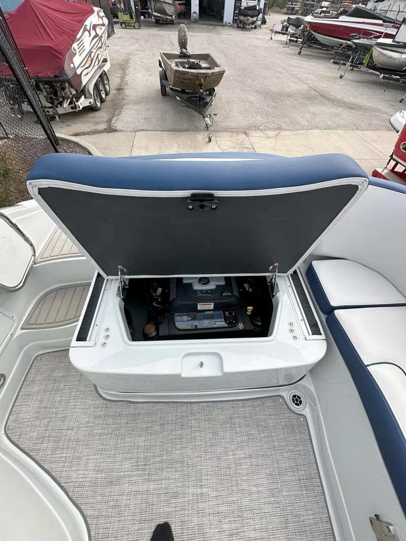 Slide: The Image of 2025 Crownline E235 boat with open storage compartment, showcasing interior details. - 13