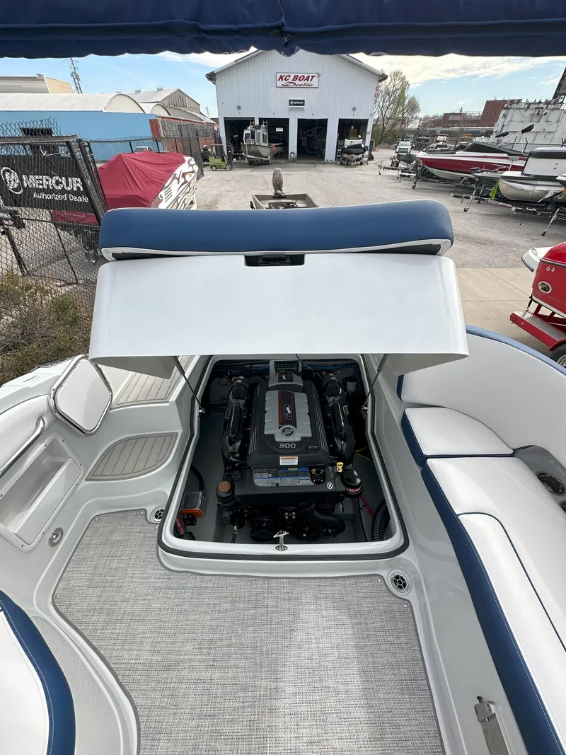 Slide: The Image of 2025 Crownline E235 boat engine compartment with open hatch, showcasing interior details. - 14