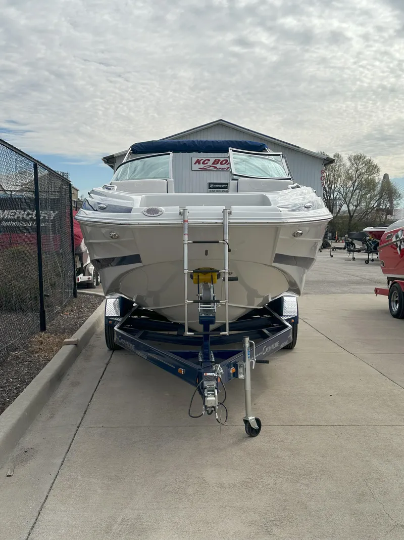 Slide: The Image of 2025 Crownline E235 boat on trailer, parked outdoors under cloudy sky. - 3
