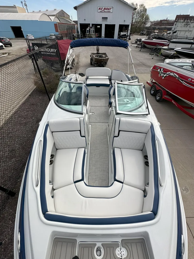 Slide: The Image of 2025 Crownline E235 boat with spacious seating, docked at a marina. - 4