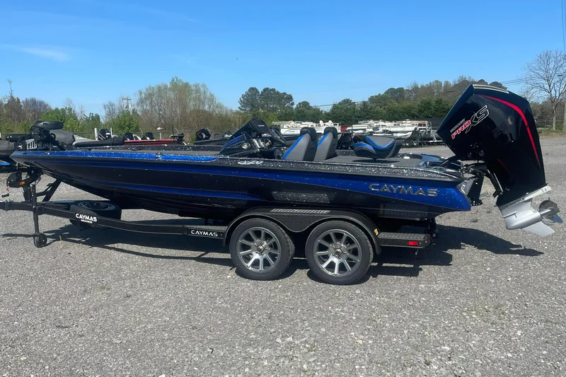 The Image of 2025 Caymas CX 20 PRO boat on trailer, blue and black design, parked outdoors. - 1