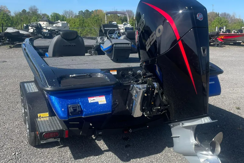 Slide: The Image of 2025 Caymas CX 20 PRO boat with powerful outboard motor, parked on gravel lot. - 4