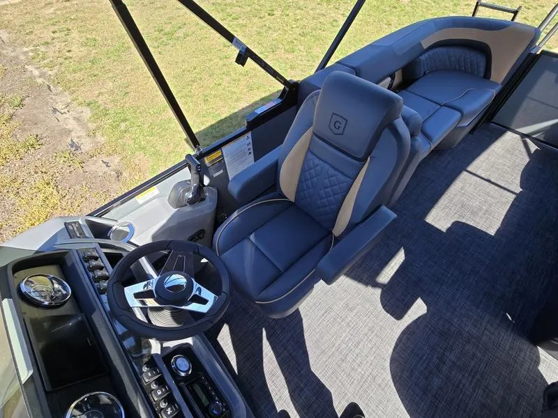 Slide: The Image of 2025 Godfrey Sweetwater 2286 SB boat interior with plush seating and modern steering console. - 12