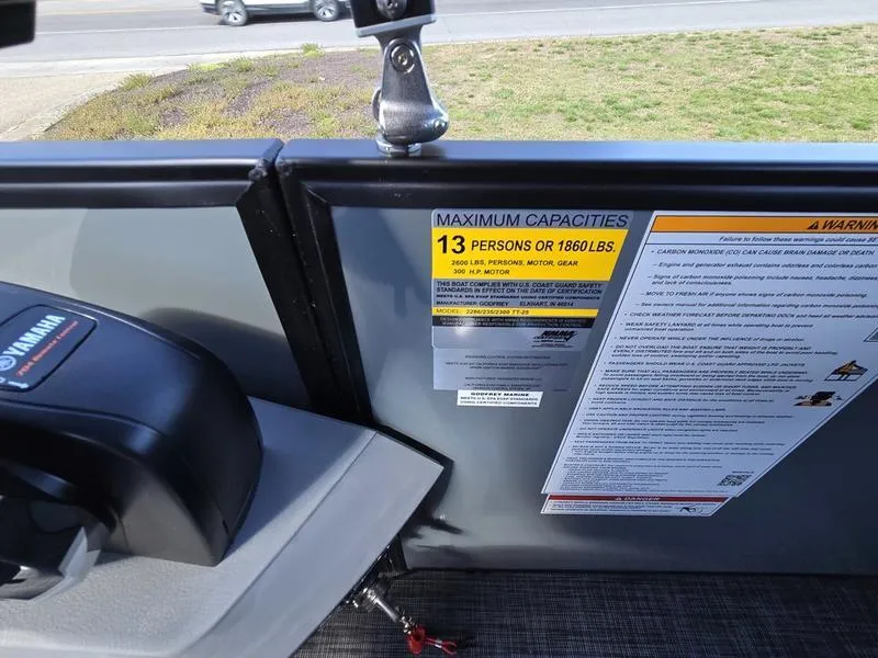 Slide: The Image of 2025 Godfrey Sweetwater 2286 SB boat capacity label, 13 persons or 1860 lbs limit. - 14