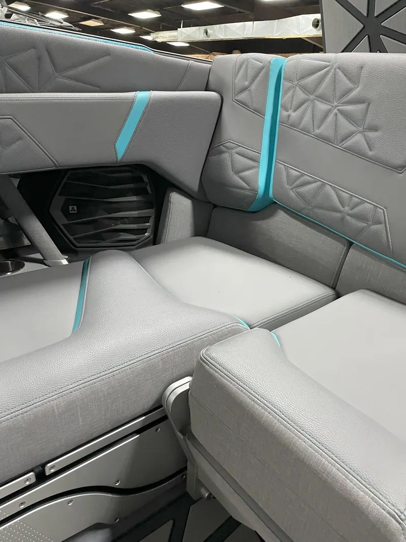Slide: The Image of 2024 Nautique Super Air Nautique G23 Paragon interior with gray and teal upholstery. - 19
