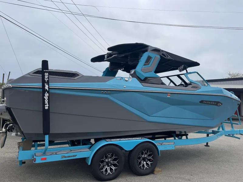 Slide: The Image of 2024 Nautique Super Air Nautique G23 Paragon boat on trailer, blue and gray design. - 2