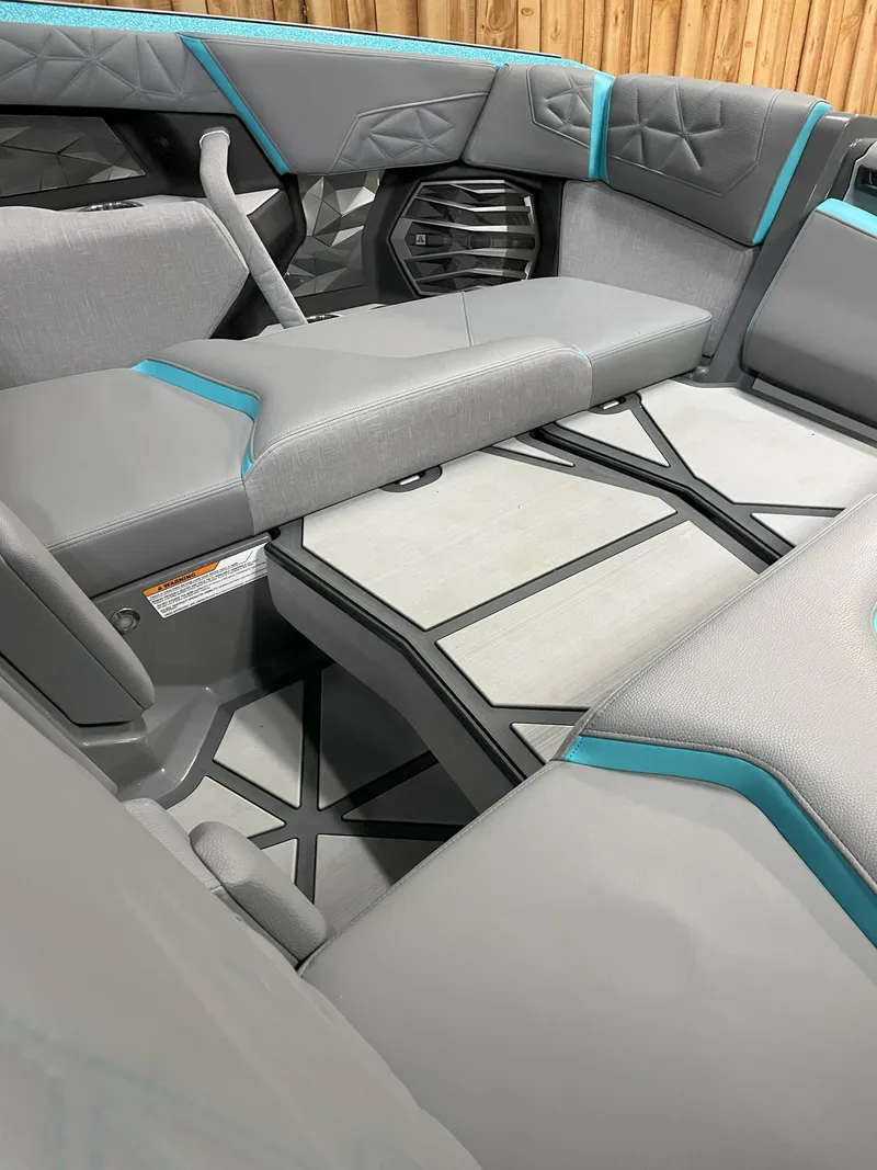 Slide: The Image of 2024 Nautique Super Air Nautique G23 Paragon interior with gray and teal seating. - 6