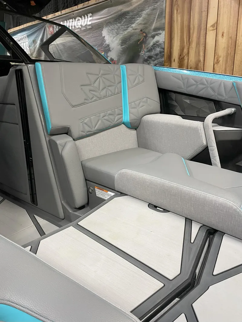 Slide: The Image of 2024 Nautique Super Air Nautique G23 Paragon interior with gray and teal seating. - 7