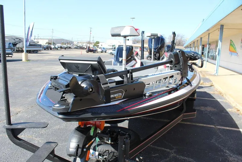 Slide: The Image of 2025 Skeeter FXR21L bass boat with advanced trolling motor, parked outdoors. - 11