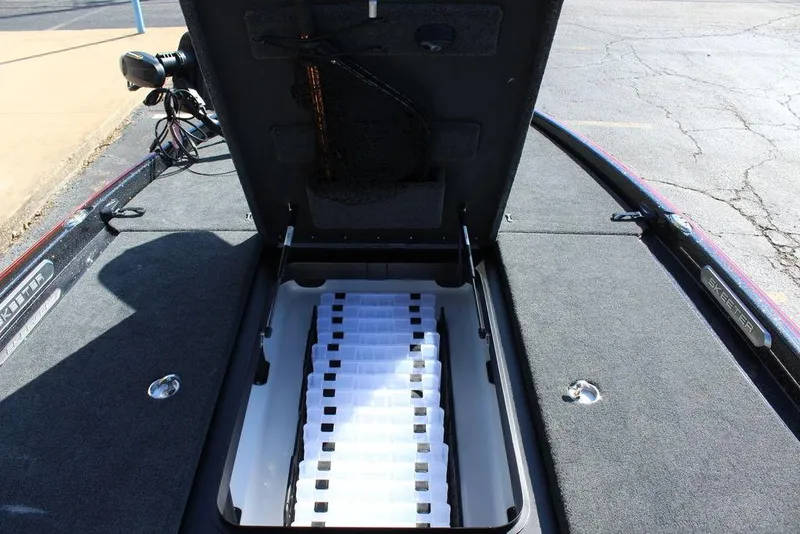 Slide: The Image of 2025 Skeeter FXR21L boat storage compartment with open lid, showcasing organized interior. - 22