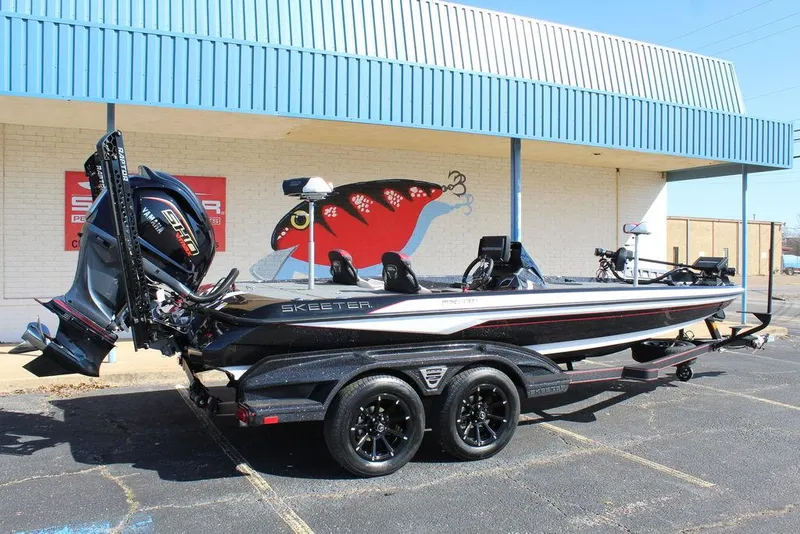 Slide: The Image of 2025 Skeeter FXR21L bass boat on trailer, parked outside a building. - 3