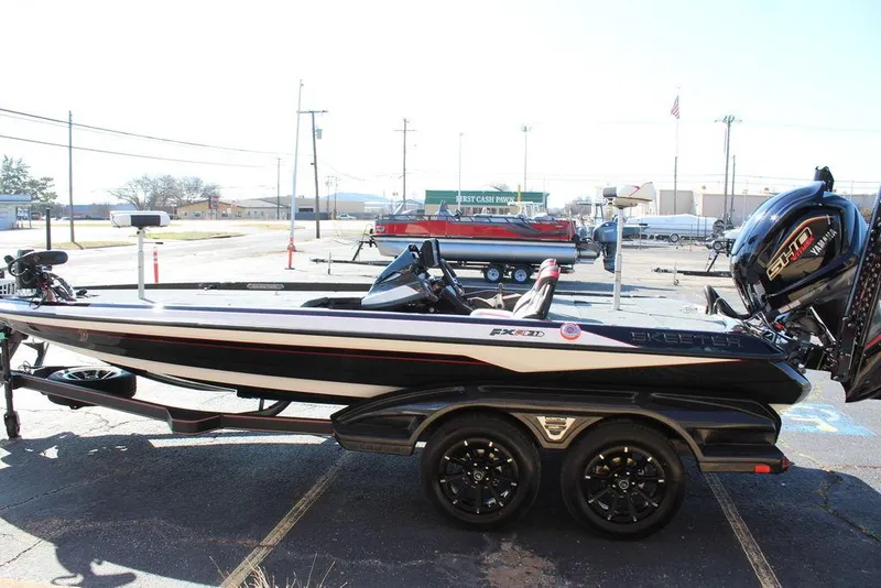 Slide: The Image of 2025 Skeeter FXR21L bass boat on trailer, parked outdoors, side view. - 8