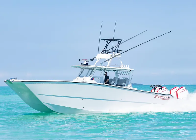 Slide: The Image of 2019 Freeman 42 LR boat cruising on turquoise water, clear sky background. - 0