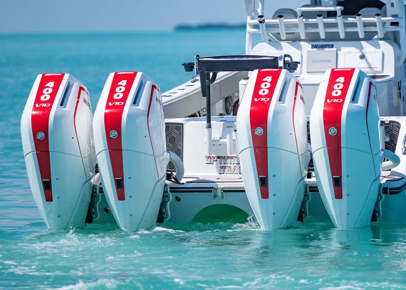 Slide: The Image of Four powerful outboard motors on a 2019 Freeman 42 LR boat in turquoise water. - 1