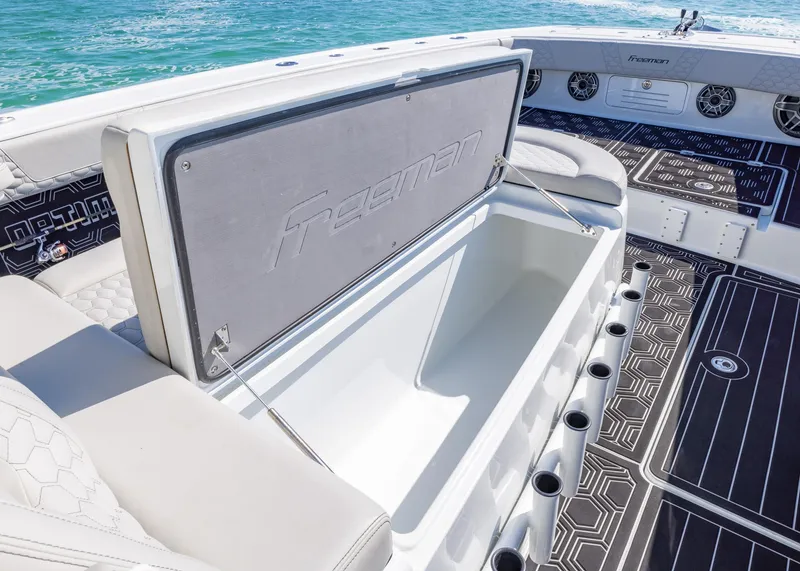 Slide: The Image of 2019 Freeman 42 LR boat interior with open storage compartment, sleek design, and ocean backdrop. - 14