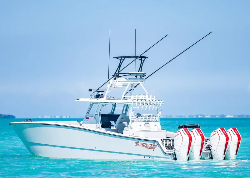 Slide: The Image of 2019 Freeman 42 LR boat on turquoise water with multiple outboard engines. - 2
