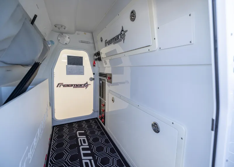 Slide: The Image of Interior of a 2019 Freeman 42 LR boat, featuring sleek white cabinetry and branded flooring. - 33