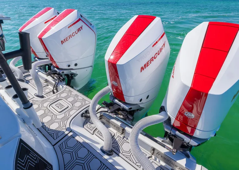 Slide: The Image of Four Mercury outboard engines on a 2019 Freeman 42 LR boat in clear blue water. - 34