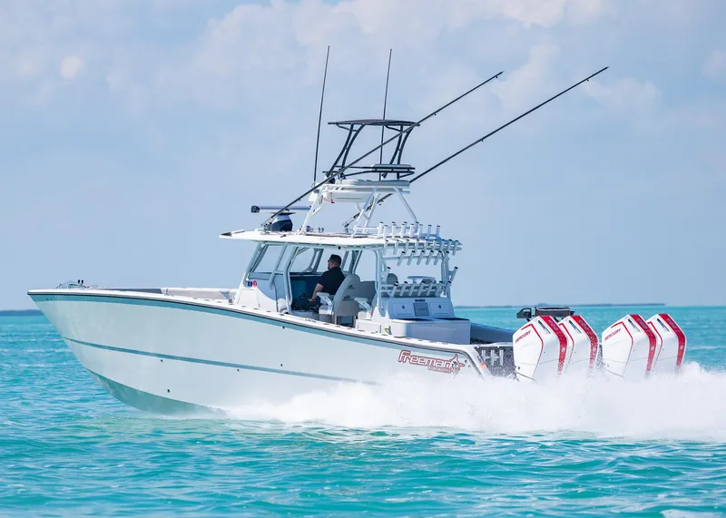 Slide: The Image of 2019 Freeman 42 LR boat cruising on turquoise water with multiple outboard engines. - 43