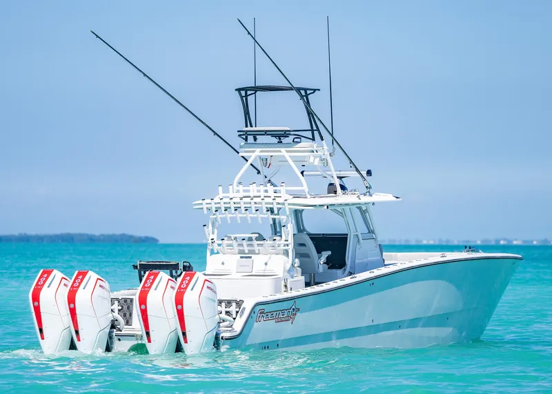 Slide: The Image of 2019 Freeman 42 LR boat with triple engines on turquoise water. - 44