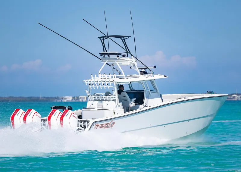 Slide: The Image of 2019 Freeman 42 LR boat cruising on turquoise water with multiple outboard engines. - 47