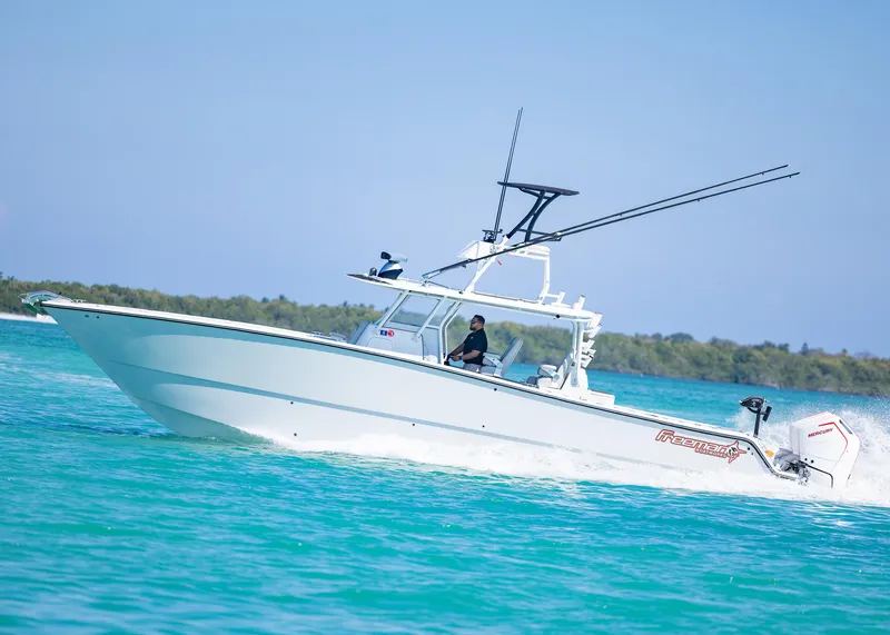 Slide: The Image of 2019 Freeman 42 LR boat cruising on turquoise water under clear blue sky. - 48