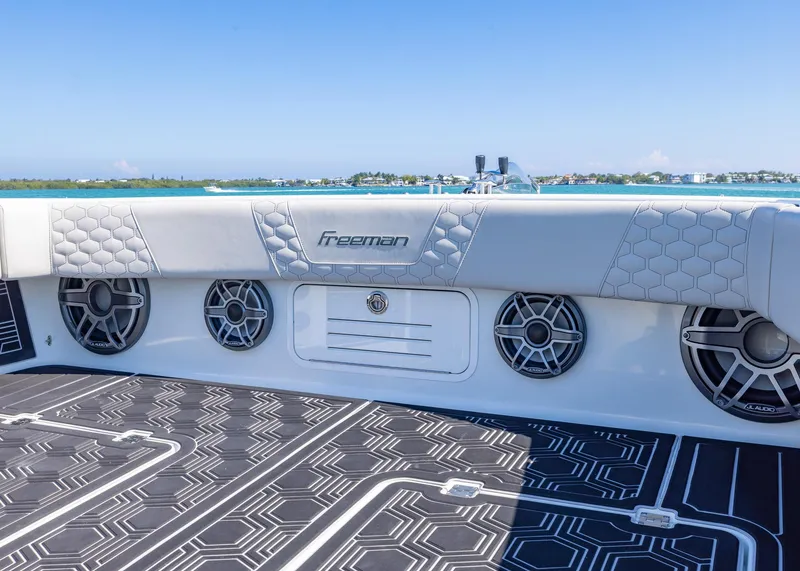 Slide: The Image of Freeman 42 LR 2019 boat interior with speakers and stylish seating, ocean view. - 6