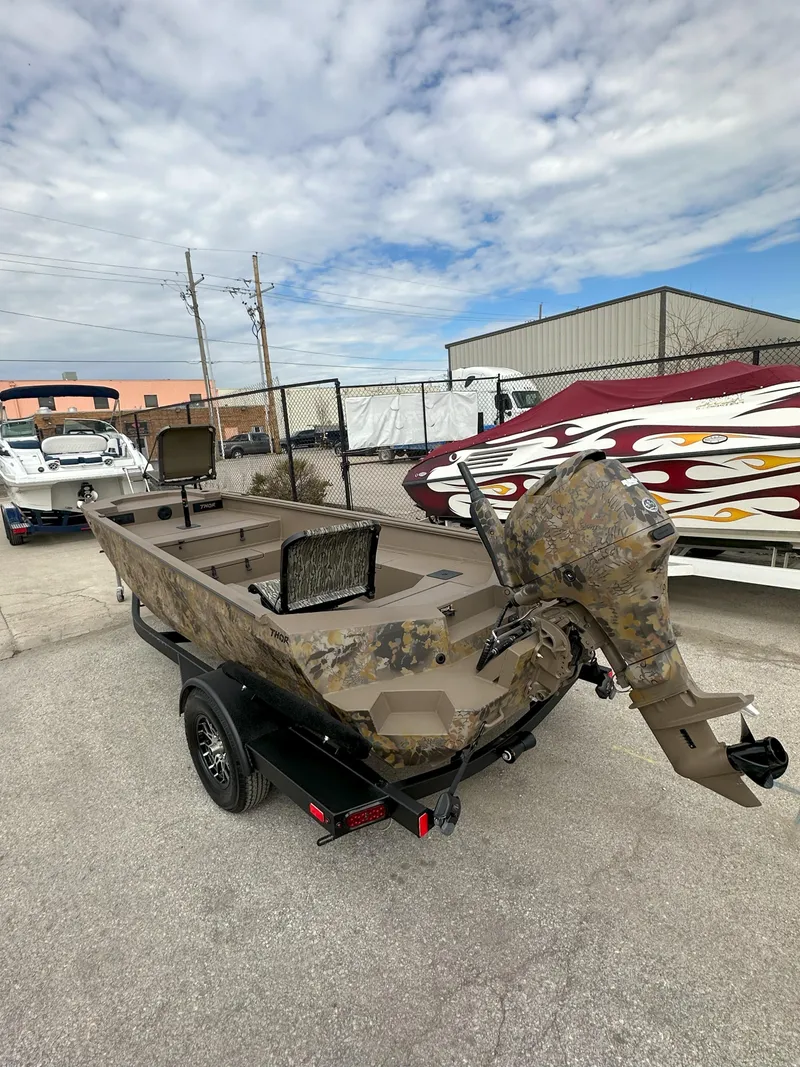 Slide: The Image of 2025 Thor 1754 Timber Hammer boat with camouflage design on a trailer. - 2