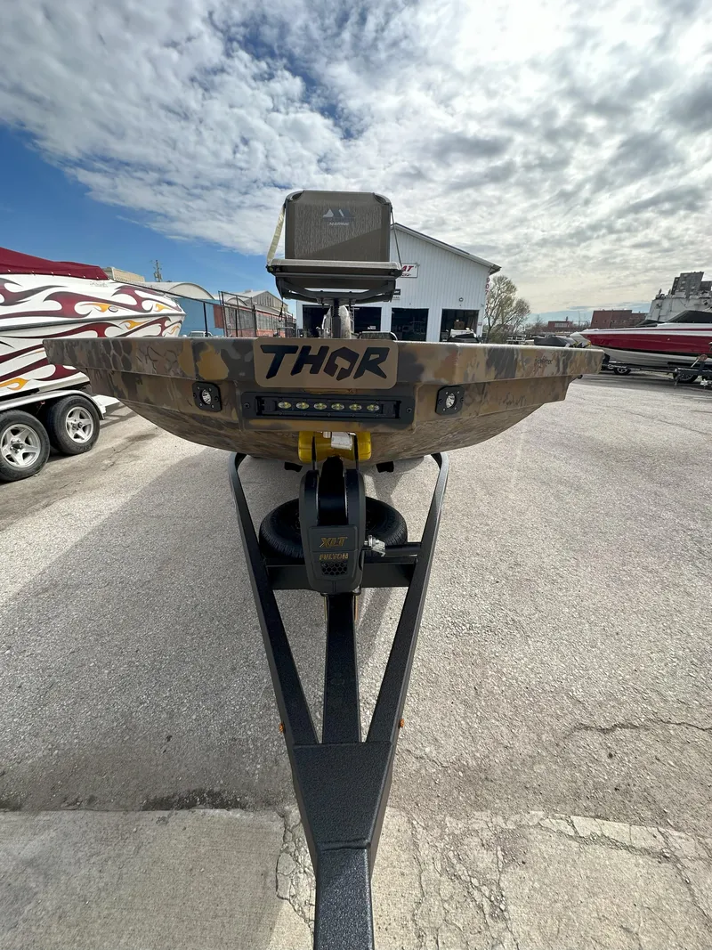 Slide: The Image of 2025 Thor 1754 Timber Hammer boat on trailer, parked outdoors under cloudy sky. - 5